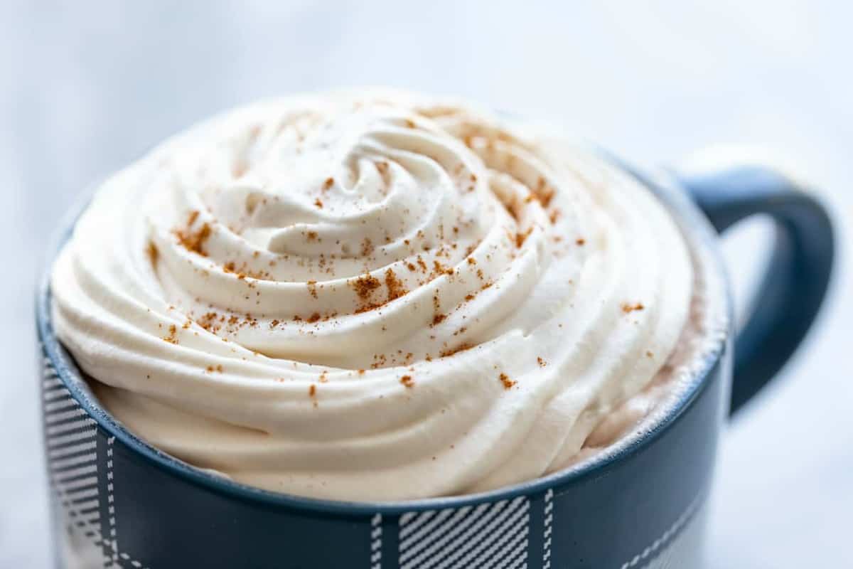 Close-up view of homemade whipped cream on a cup of coffee