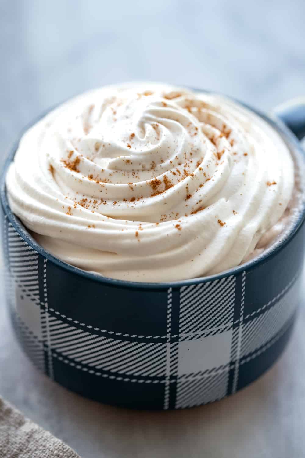 Coffee topped with homemade whipped cream in a blue mug