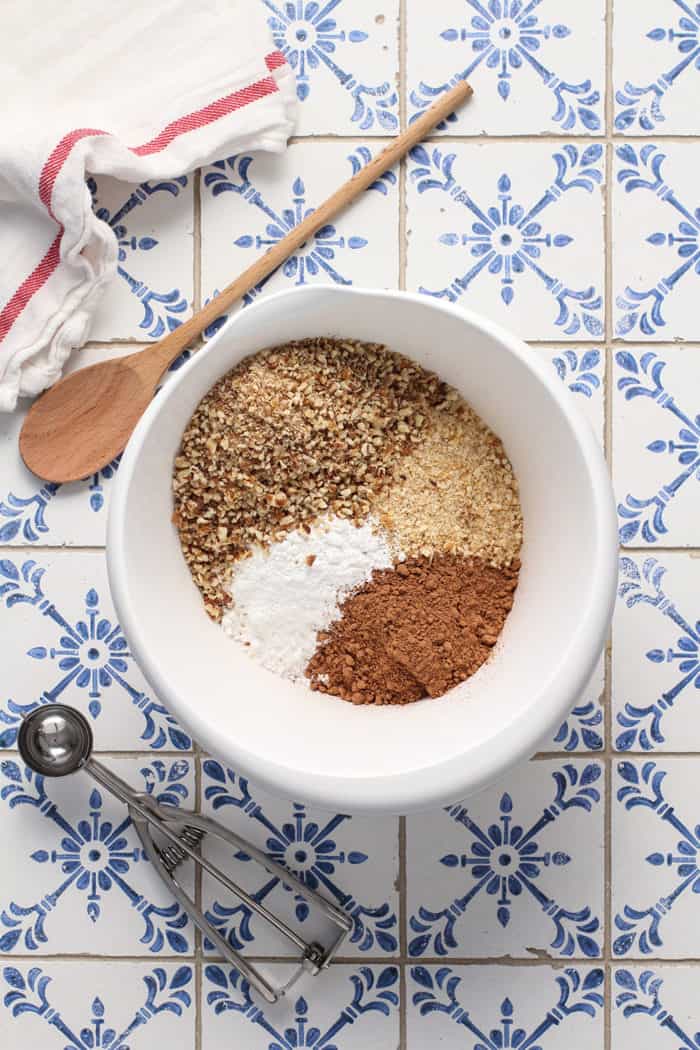 Dry ingredients for rum balls in a white bowl, about to be stirred together