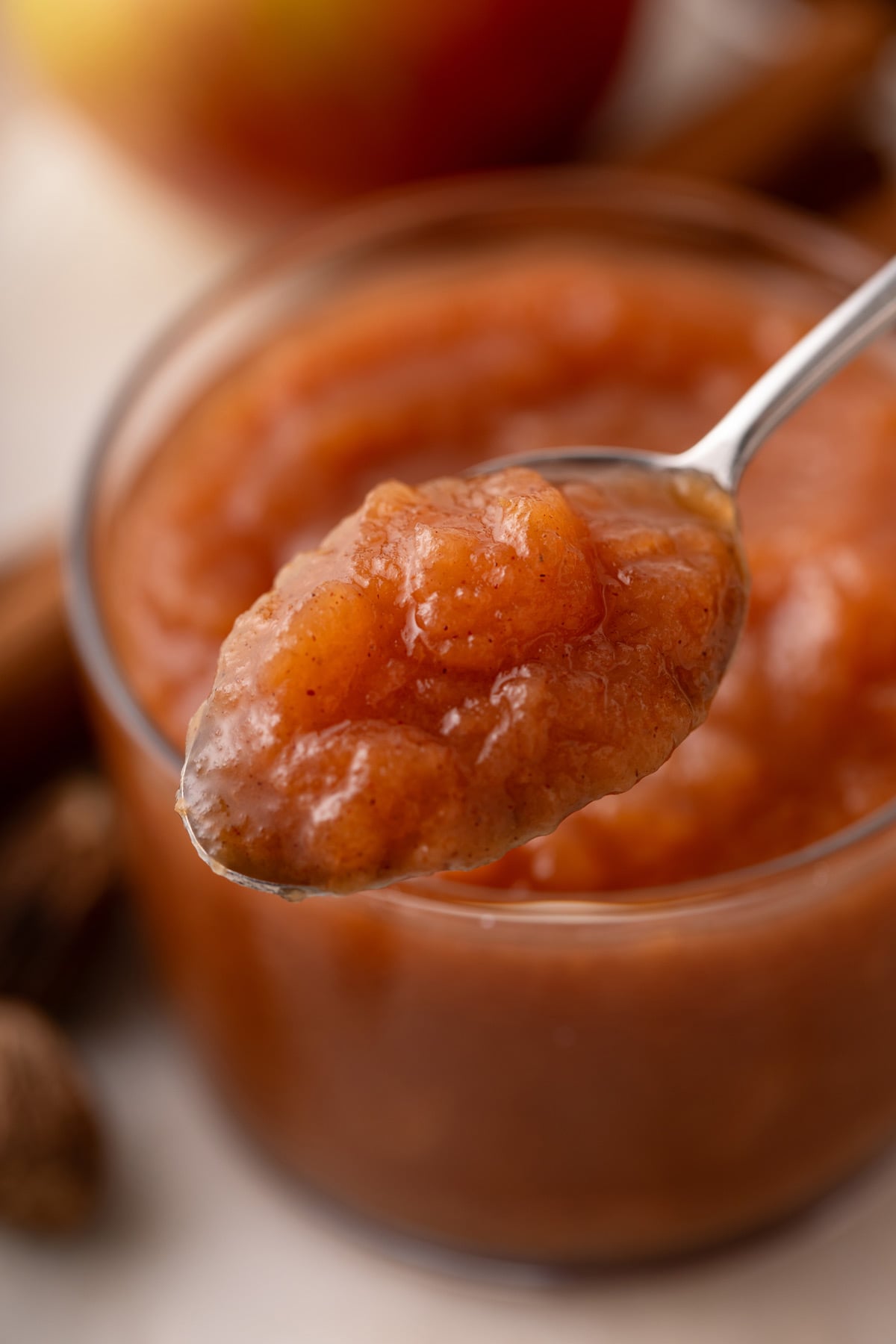 Spoonful of crockpot applesauce being held up to the camera.