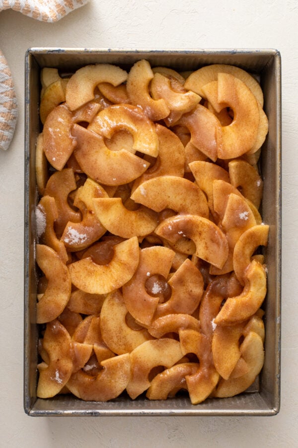 Ingredients for apple crisp filling mixed in a baking pan.