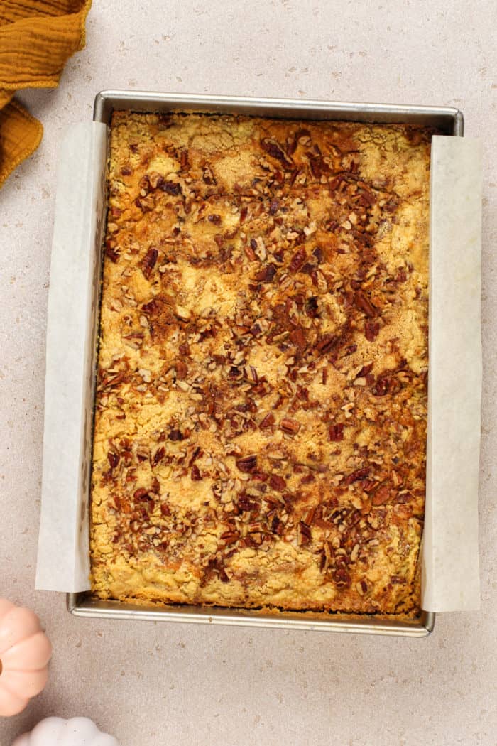 Baked pumpkin crunch cake in a parchment-lined cake pan.