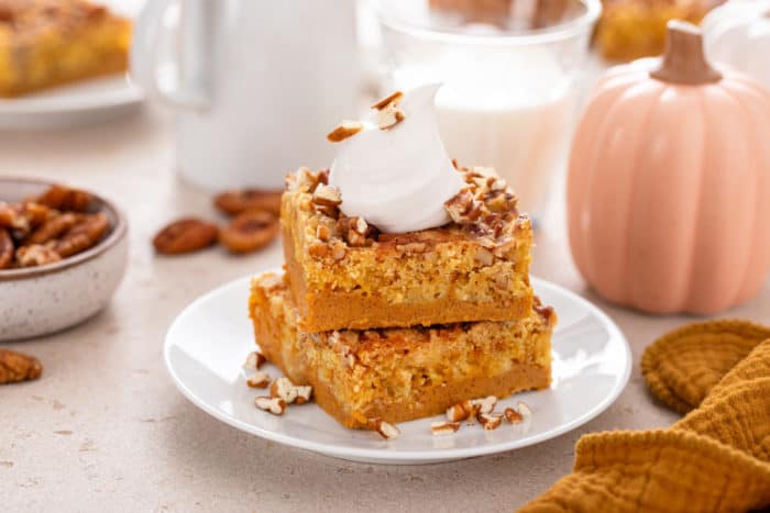 Side view of two slices of pumpkin crunch cake on a white plate.