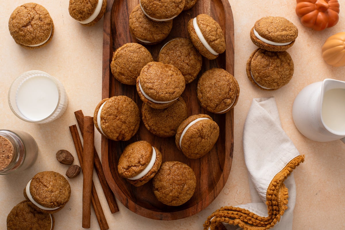 Overhead view of pumpkin molasses cookies arranged on a wooden platter.