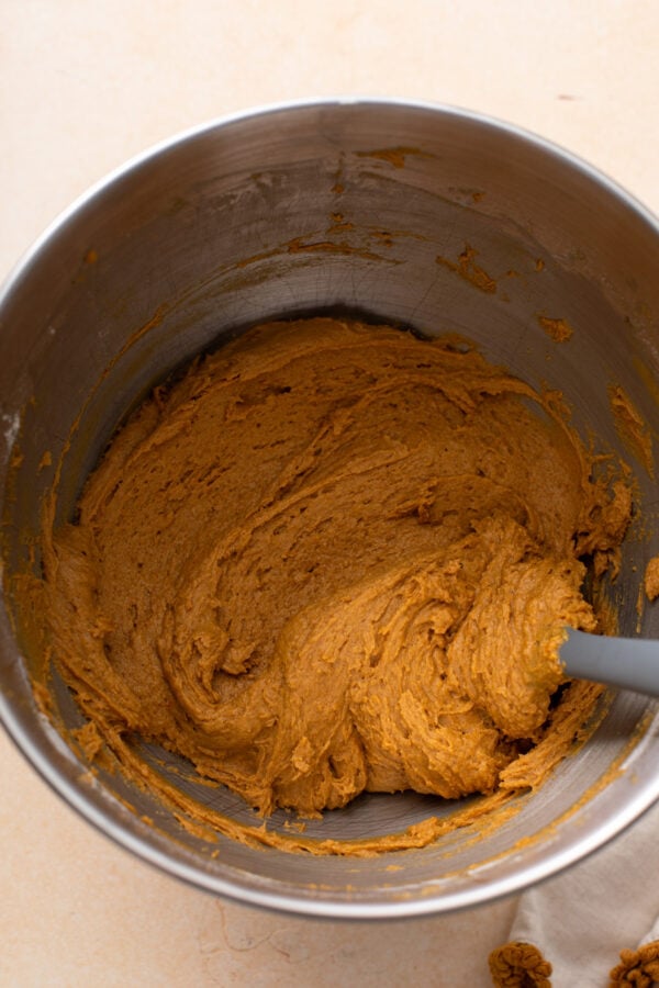 Dough for pumpkin molasses cookies in a metal mixer bowl.