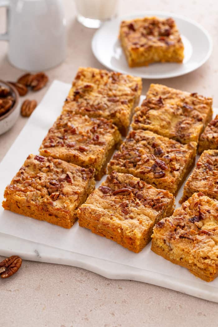 Sliced pumpkin crunch cake on a marble board.