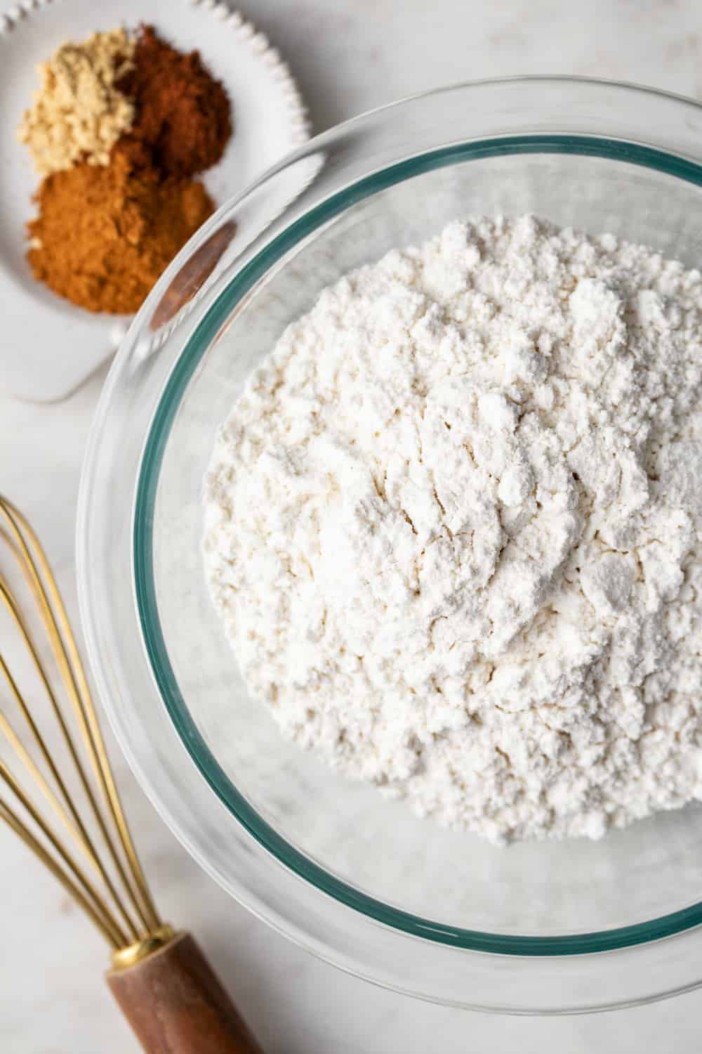 Dry ingredients for gingerbread cake in a glass mixing bowl