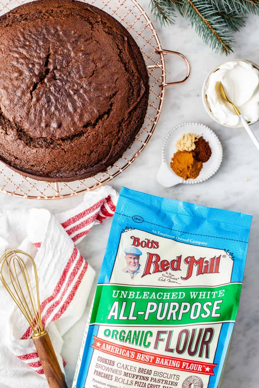 Gingerbread cake on a wire rack next to a bag of flour and spices