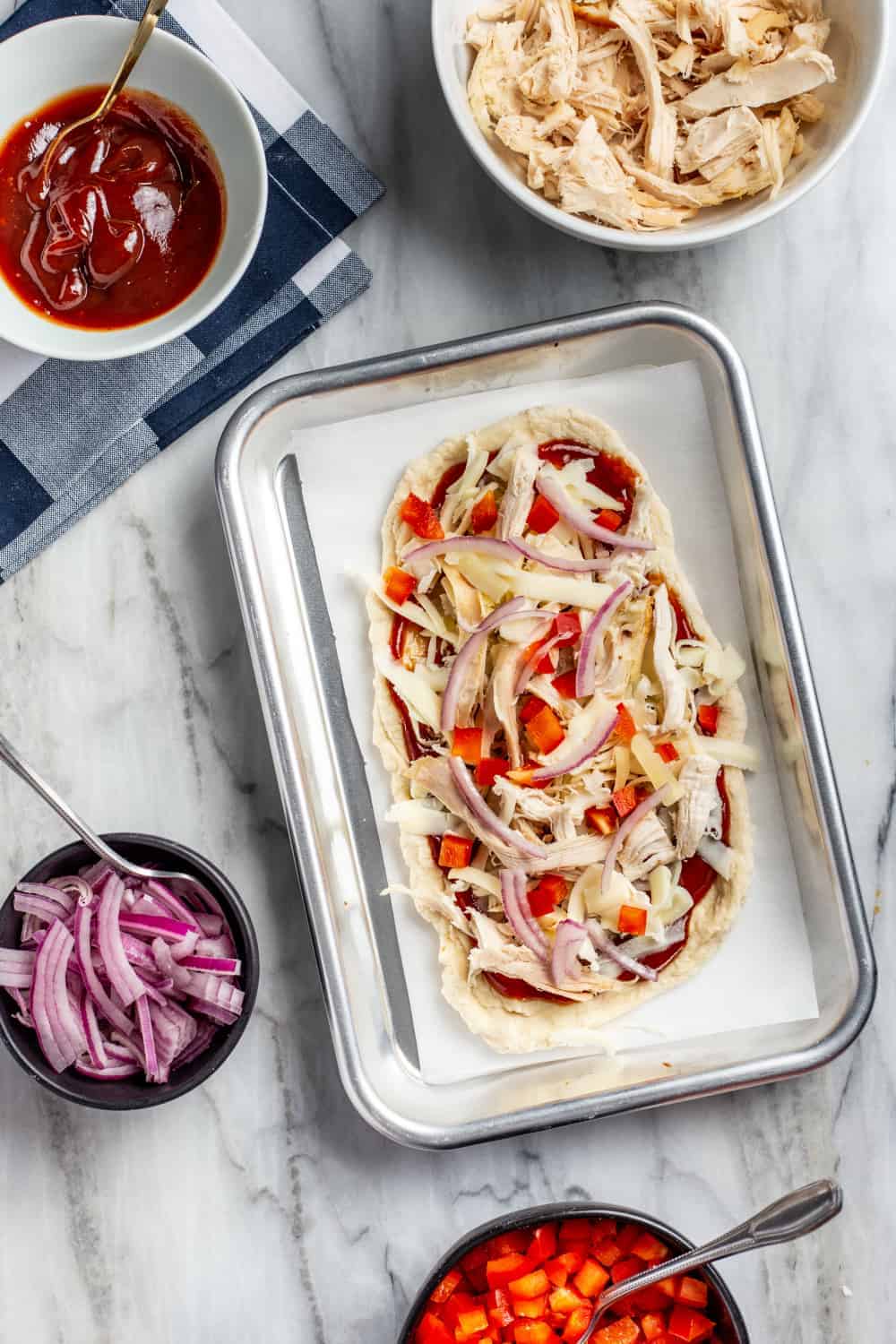 Barbecue chicken pizza on a mini baking sheet, ready to be baked