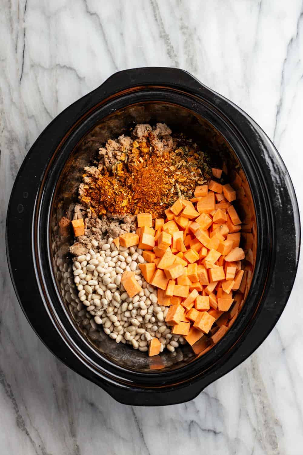 Ingredients for white bean chili in the bowl of a slow cooker