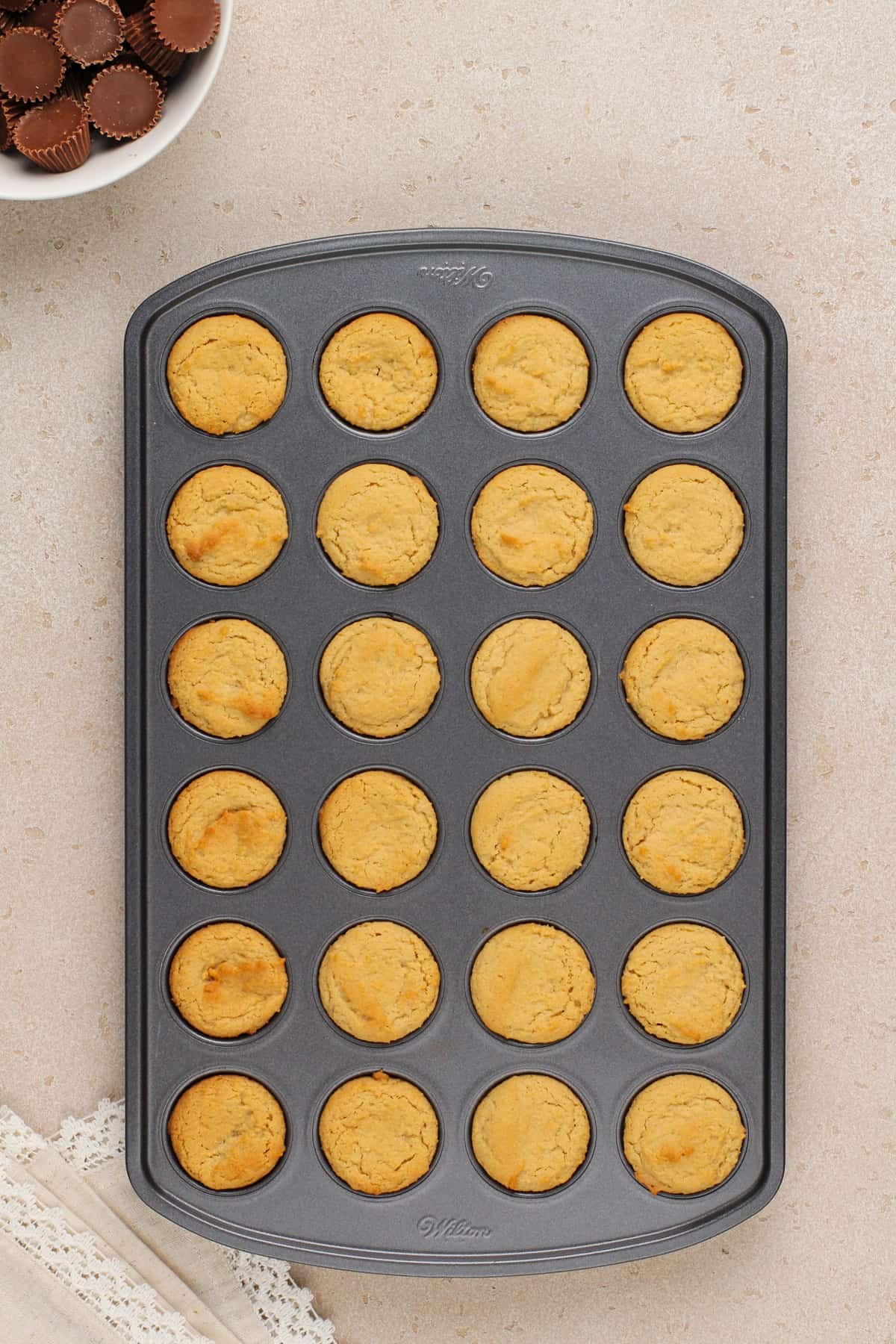 Baked peanut butter cup cookies in a mini muffin tin.