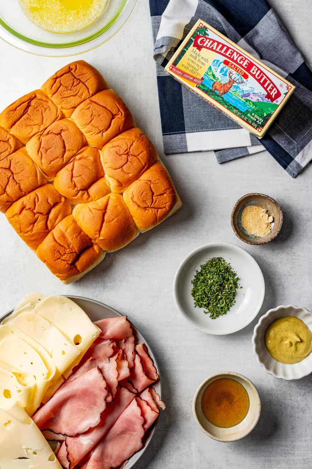 Ingredients for ham and cheese sliders on a countertop surface