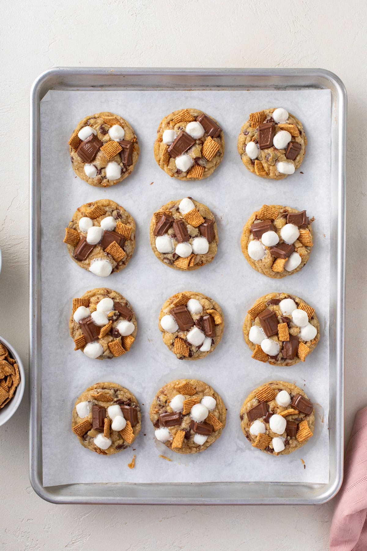 Baked s'mores cookies on a parchment-lined baking sheet.