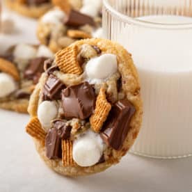 S'mores cookie leaning against a glass of milk.