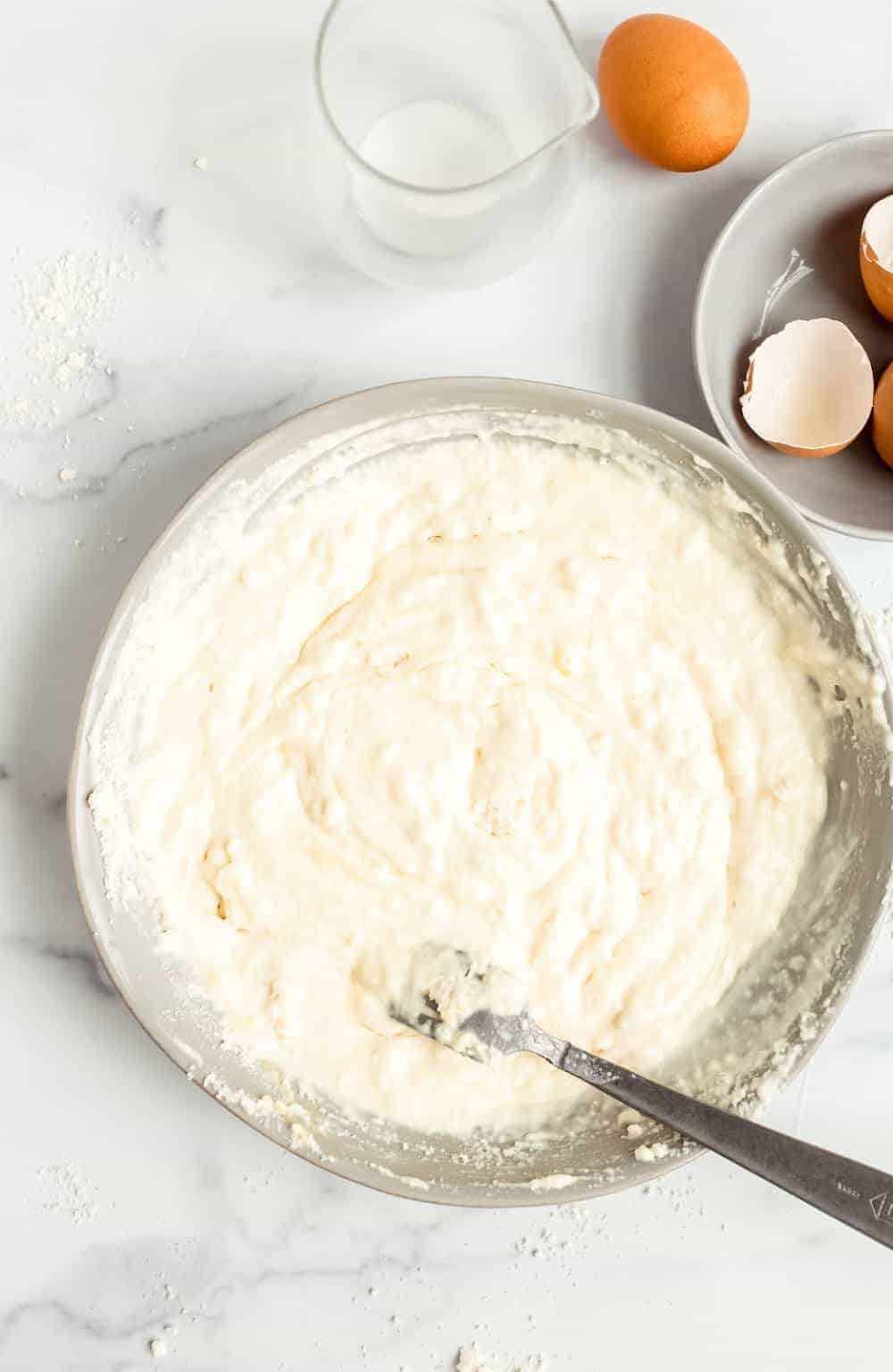 Bisquick pancake batter in a mixing bowl on a marble countertop