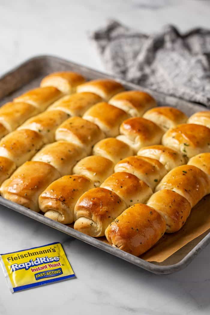Sheet pan of freshly baked garlic and herb parker house rolls