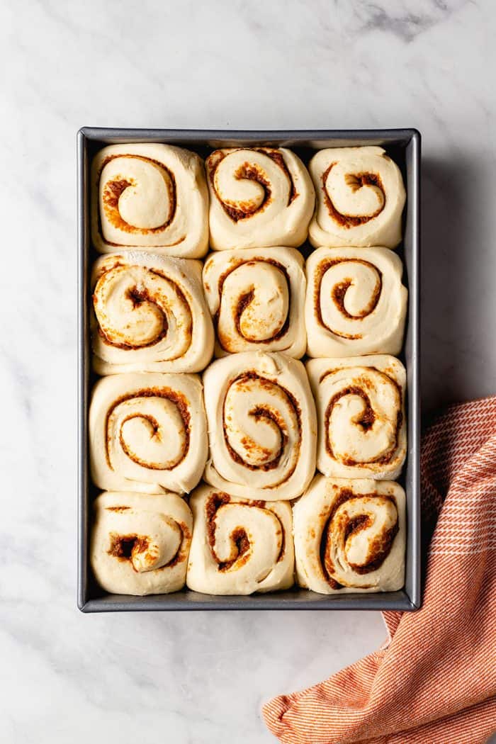 Overhead view of sliced pumpkin spice cinnamon rolls after rising, before baking