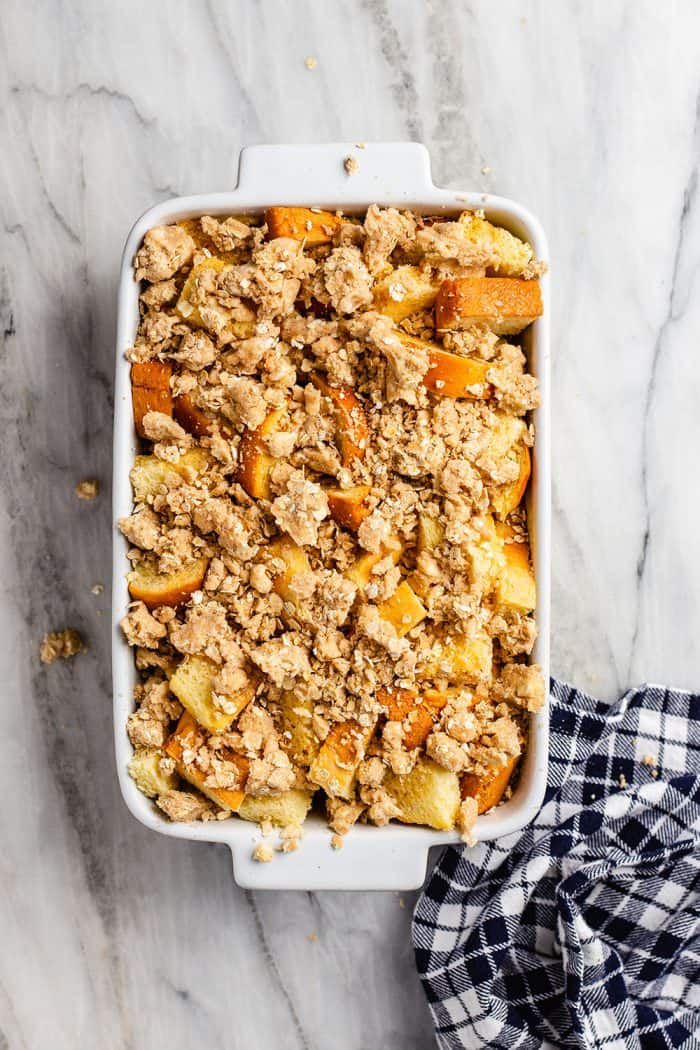 Overnight french toast casserole in a white baking dish, assembled and ready to be baked