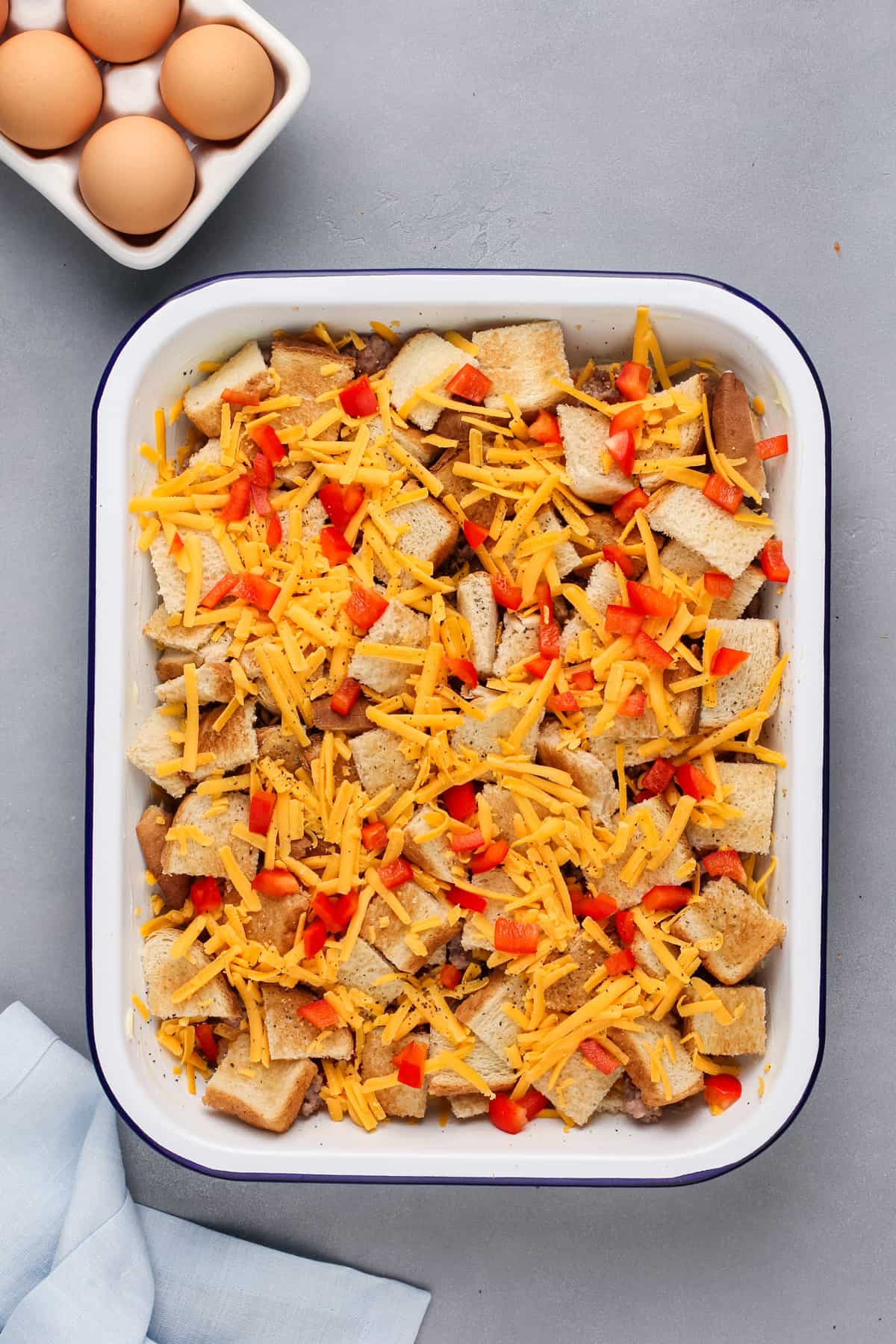 Bread and cheese layered in a baking dish for make-ahead breakfast casserole.