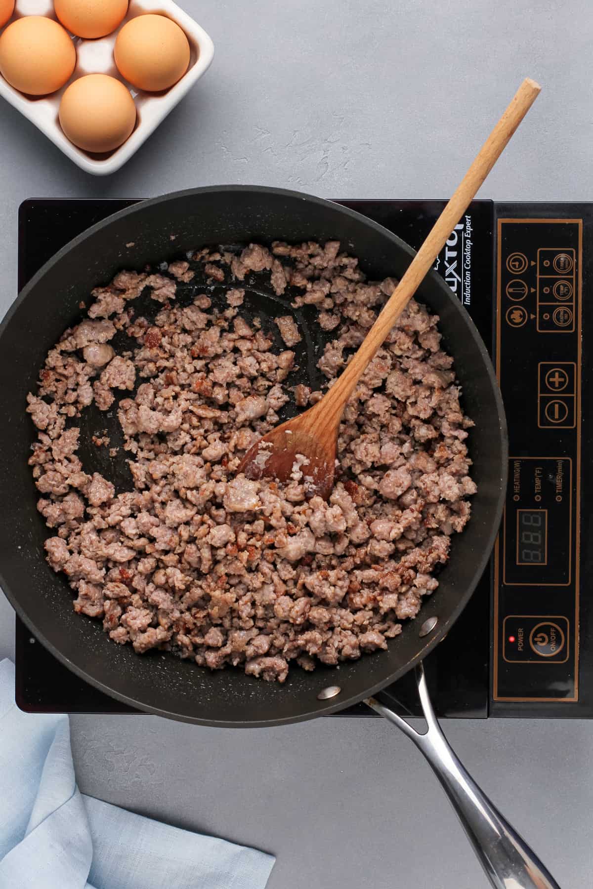 Ground pork sausage cooked in a black skillet.