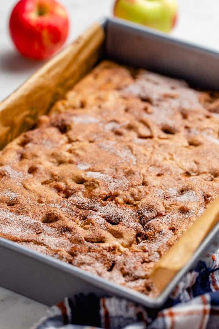 Freshly baked apple bars in a parchment lined baking pan