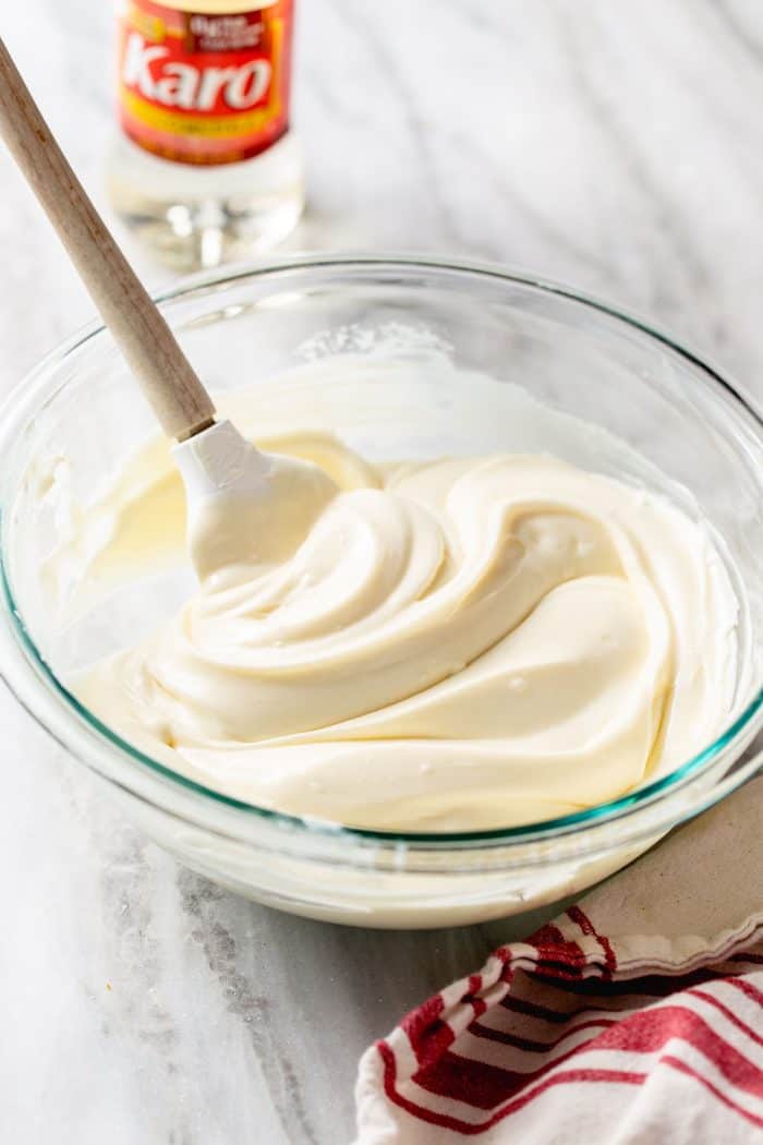 Spatula stirring no-bake cheesecake bar filling in a glass mixing bowl