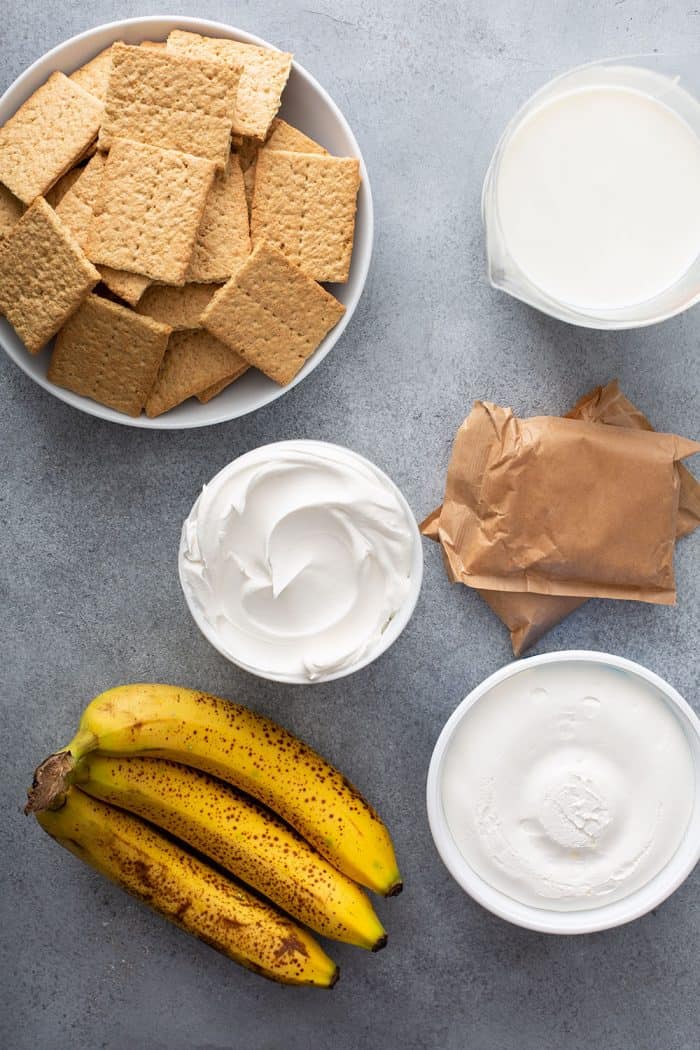 Ingredients for banana cream pie eclair cake arranged on a gray counter