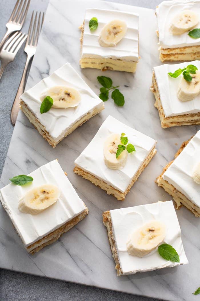 8 slices of banana cream pie eclair cake arranged on a marble surface