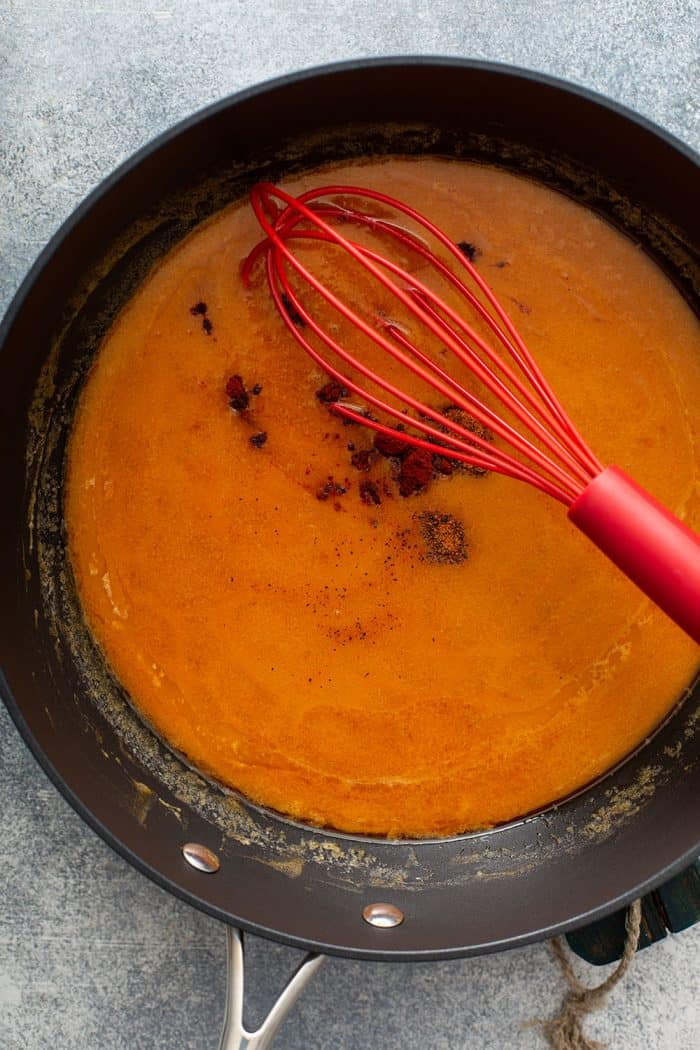 Whisk stirring spices into buffalo sauce for buffalo chicken dip