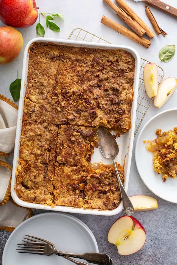 Spoon about to scoop a slice of apple dump cake out of the pan