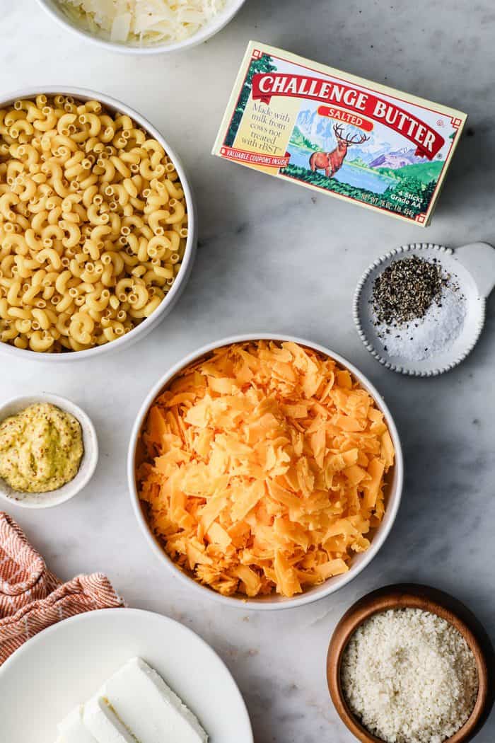 Baked macaroni and cheese ingredients arranged on a marble counter