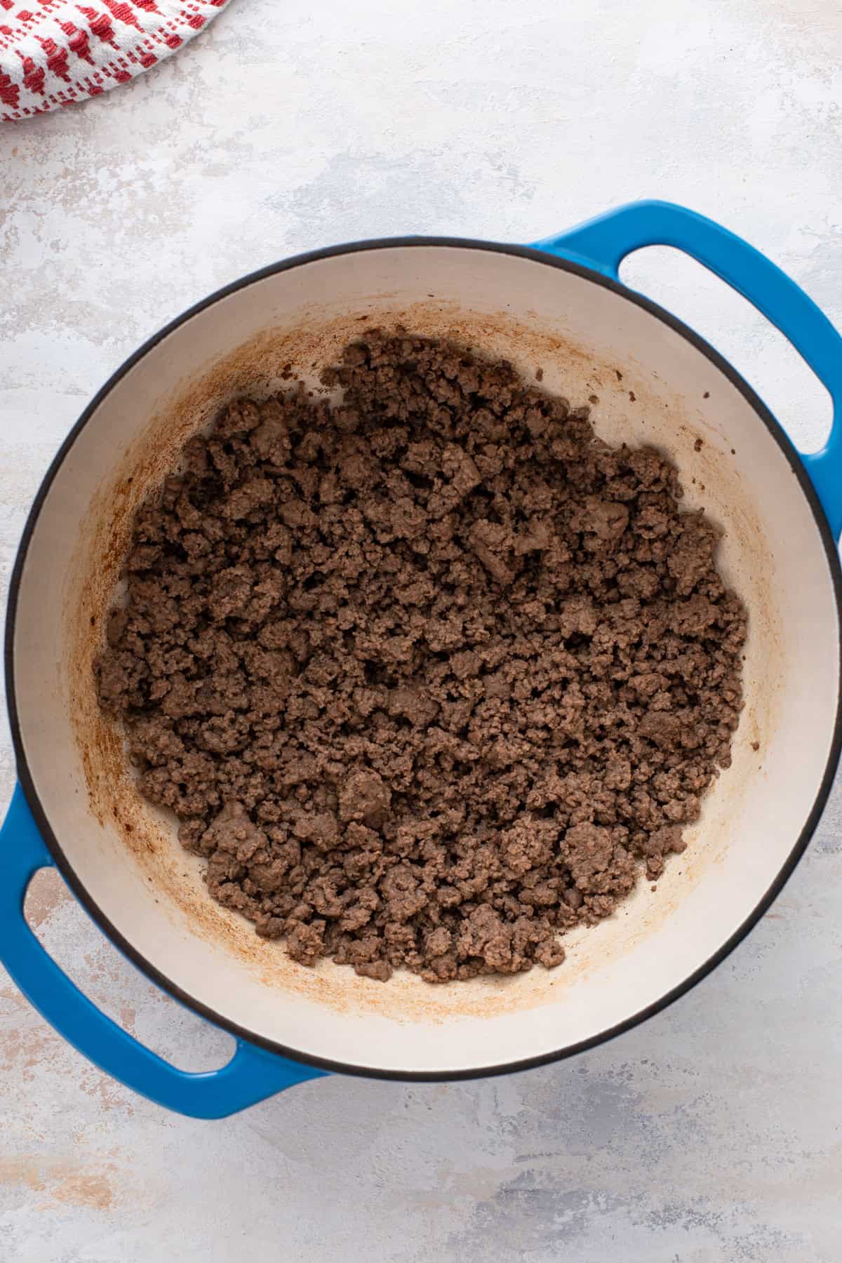 Ground beef cooked in a blue dutch oven.