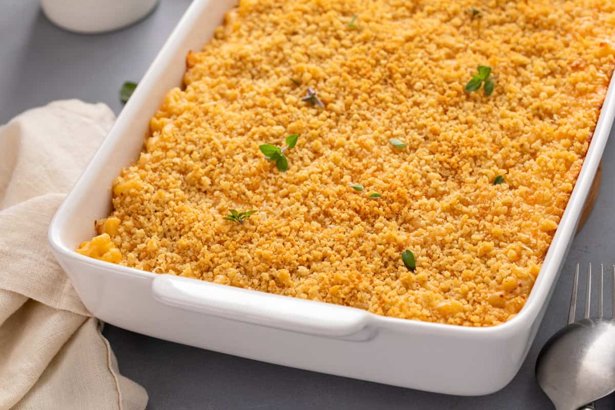 Baked mac and cheese in a white casserole dish on a countertop.