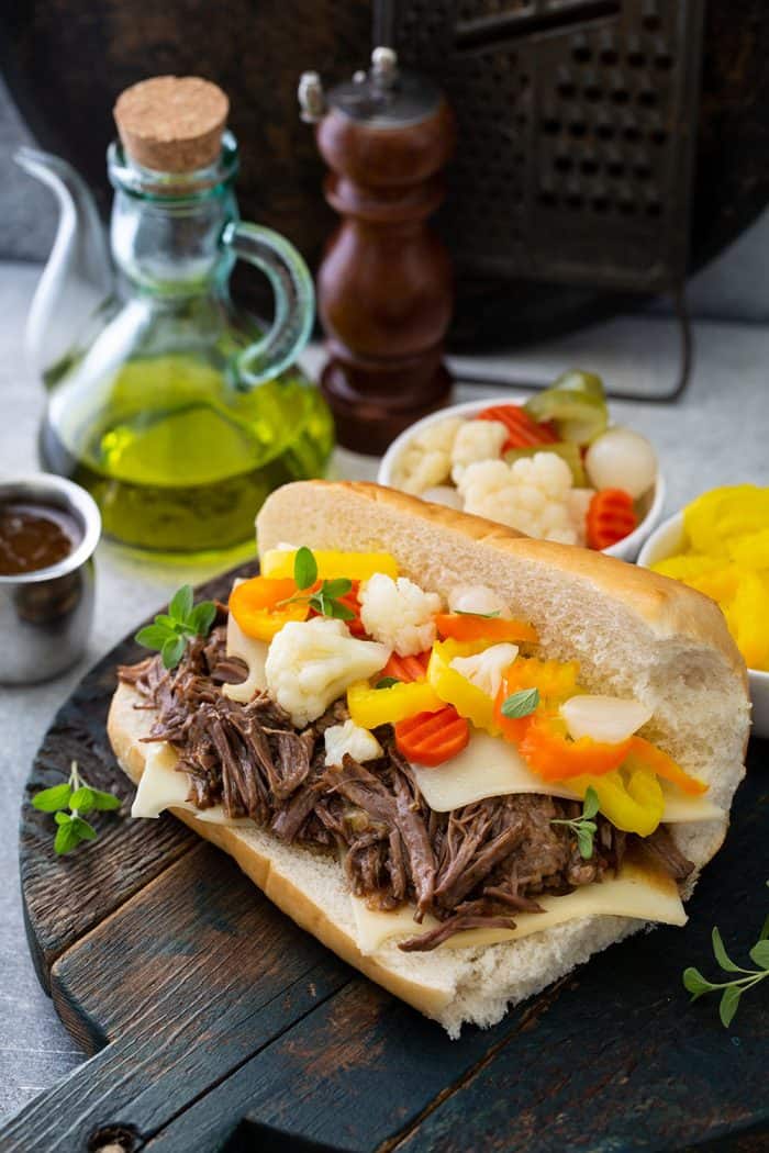 Assembled italian beef sandwich topped with giardiniera