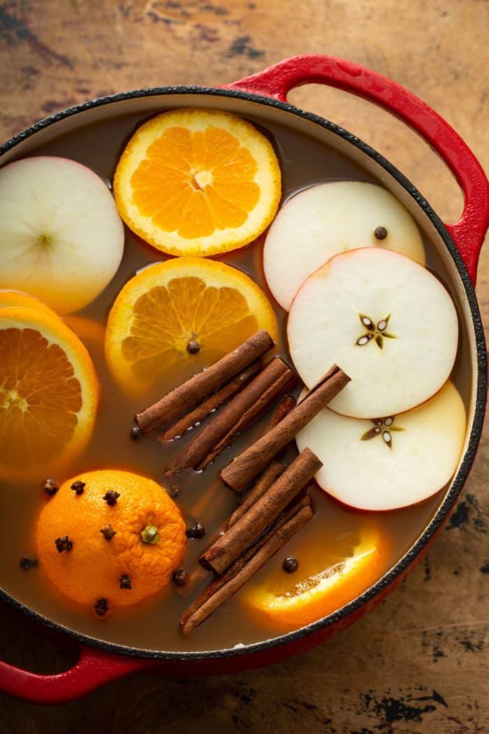 Ingredients for hot wassail in a red dutch oven, ready to be mulled