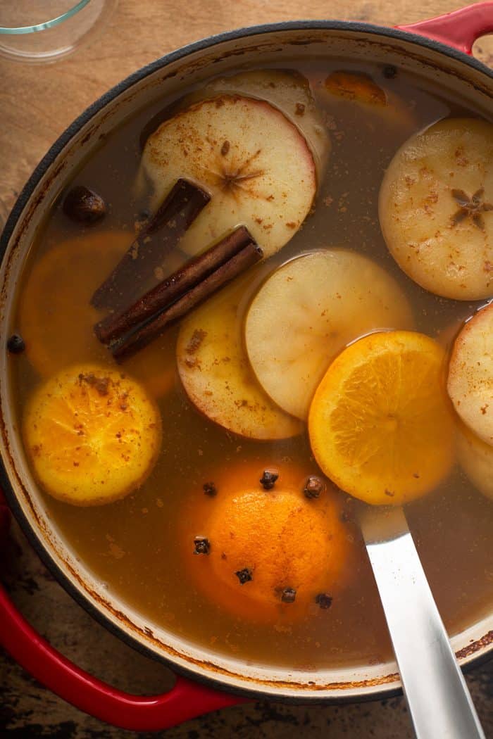 Mulled wassail in a red dutch oven with a ladle in it