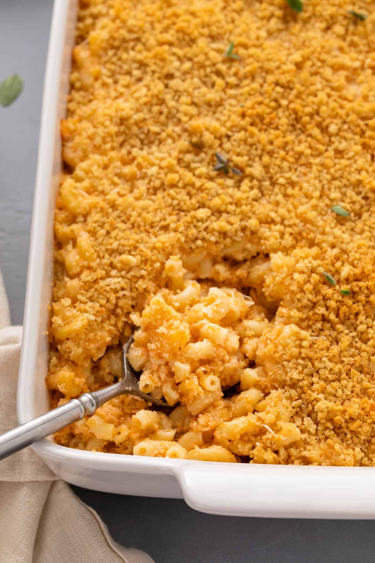 Spoon in a casserole dish of baked mac and cheese.