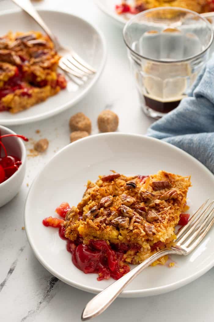 Two white plates with cherry pineapple dump cake on a table