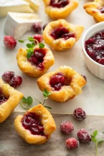 Cranberry brie bites scattered on a marble board