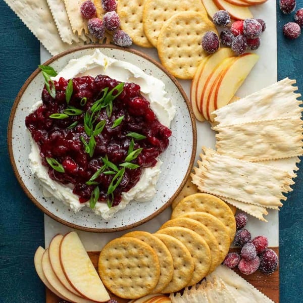 Plate of cranberry cream cheese dip surrounded by crackers