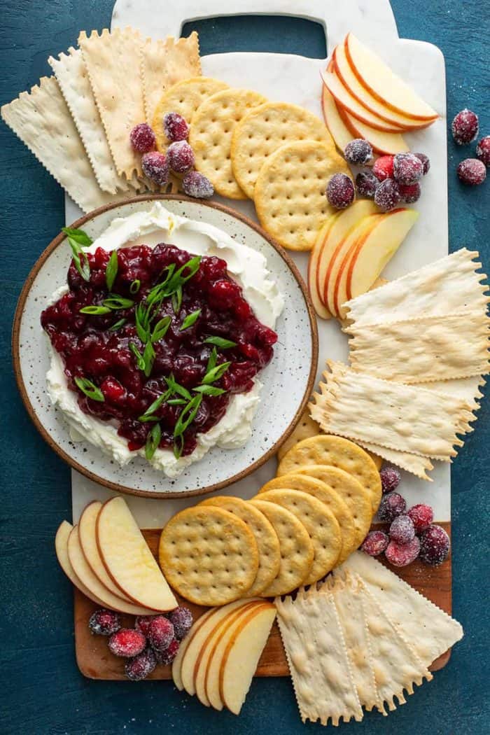 Plate of cranberry cream cheese dip surrounded by crackers