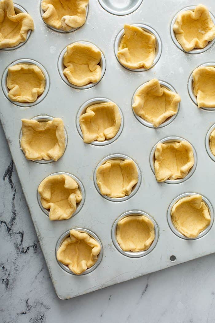 Crescent dough nestled into muffin tins