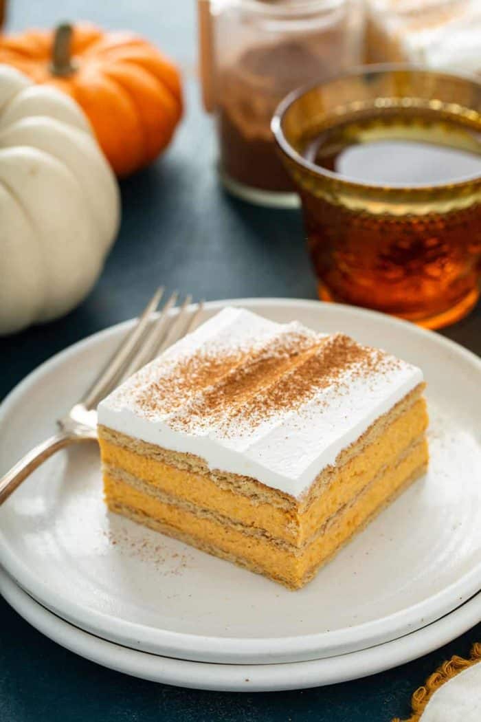 Slice of pumpkin eclair cake next to a fork on a white plate