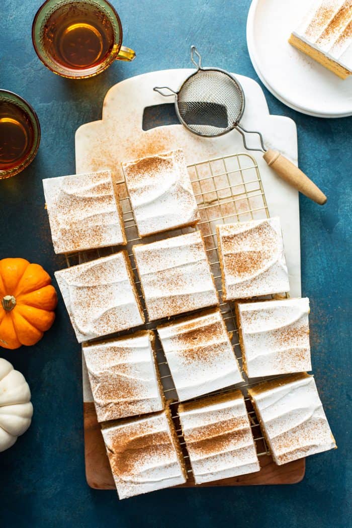 Eclair cake cut into pieces on a cutting board and dusted with cinnamon