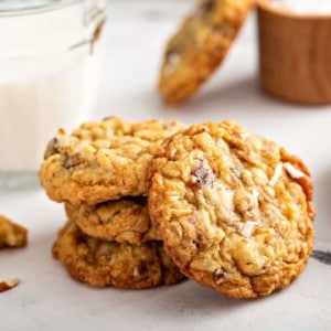 Ambrosia cookies stacked next to a glass of milk on a countertop