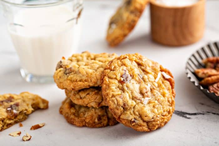 Ambrosia cookies stacked next to a glass of milk on a countertop