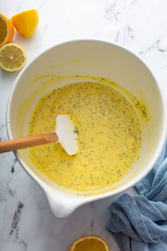 Citrus poppy seed cake batter in a white mixing bowl