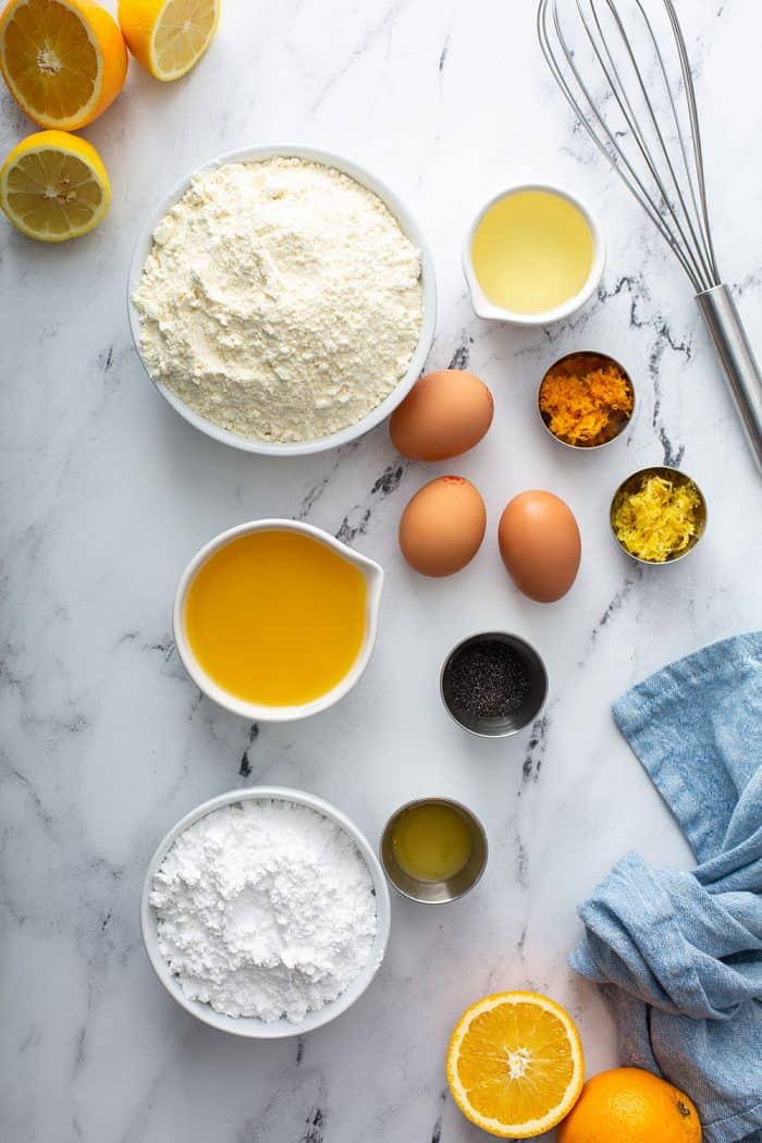 Citrus poppy seed cake ingredients on a marble counter