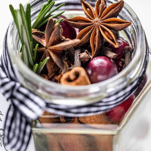 Close up of the open mouth of a glass jar filled with stovetop potpourri