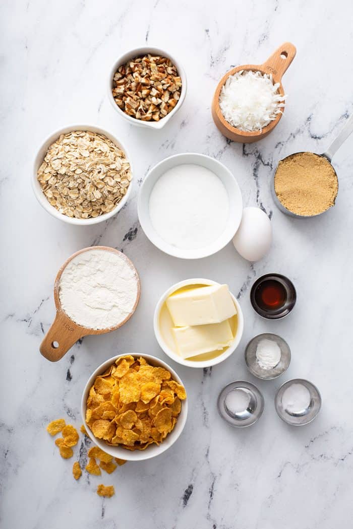 Ingredients for cornflake cookies arranged on a marble counter